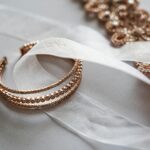 Close-up of luxurious rose gold jewelry on a sheer satin fabric, perfect for bridal occasions.