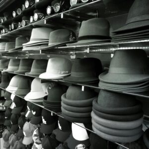 Aesthetic black and white shot featuring rows of hats on shelves in a store.
